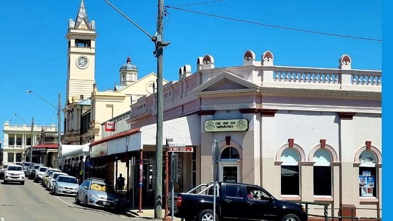 Darwin to Cairns road trip Historic buildings and clock tower lining the main street of Charters Towers, Queensland, with parked cars and classic heritage architecture under a clear blue sky