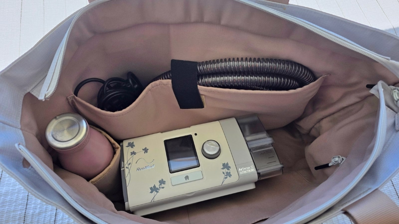 ResMed CPAP travel bags ResMed AirSense CPAP machine, hose and water bottle packed inside a Luxe travel tote bag for travel