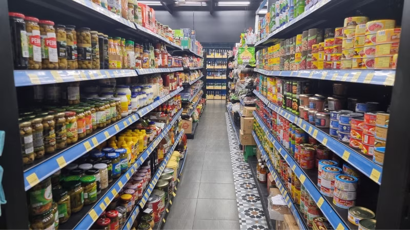 Long Stays in Vietnam Aisle stocked with canned goods, sauces and condiments at Moonmilk grocery store in Da Nang